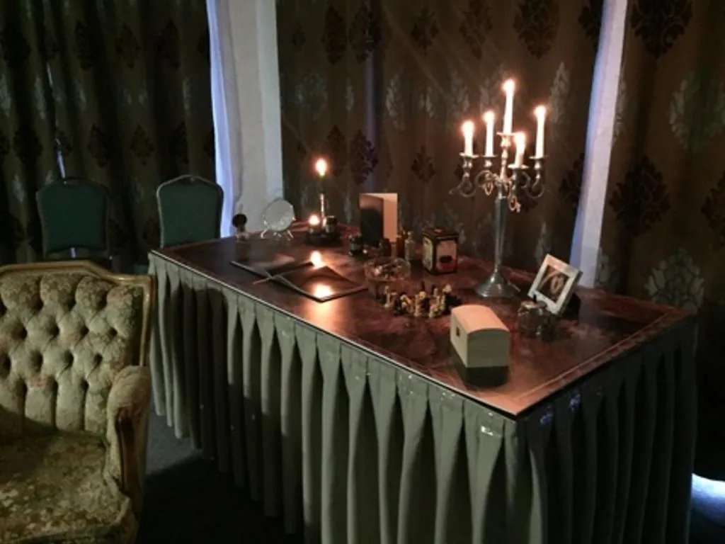 Scenografia gry „Biurko Gustawa”: biurko ze świecznikiem i rekwizytami