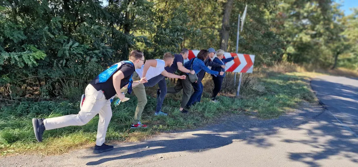 Uczestnicy gry terenowej na starcie zadania przy drodze