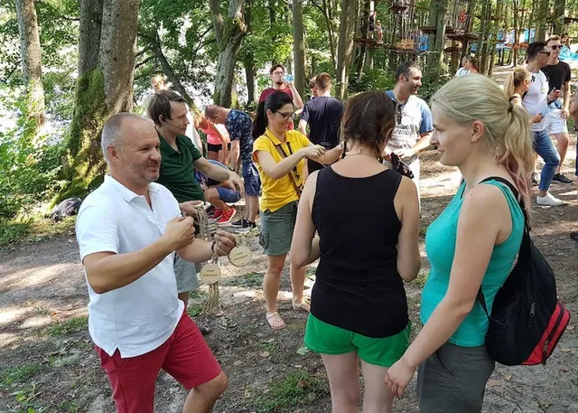 Grupa uczestników gry terenowej w lesie nad wodą